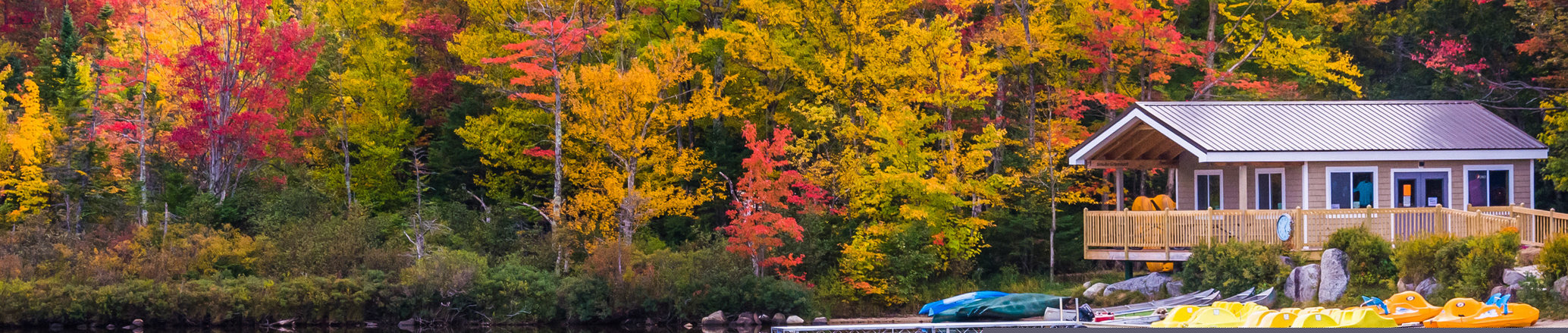 Boathouse and fall colors reflecting in Echo Lake, in Franconia Notch State Park, New Hampshire